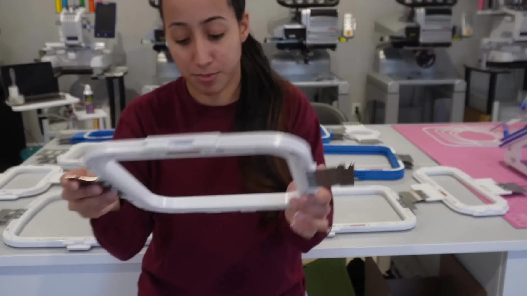 Angela holds up the 8x9 magnetic hoop—the daily workhorse size in many commercial embroidery workflows.