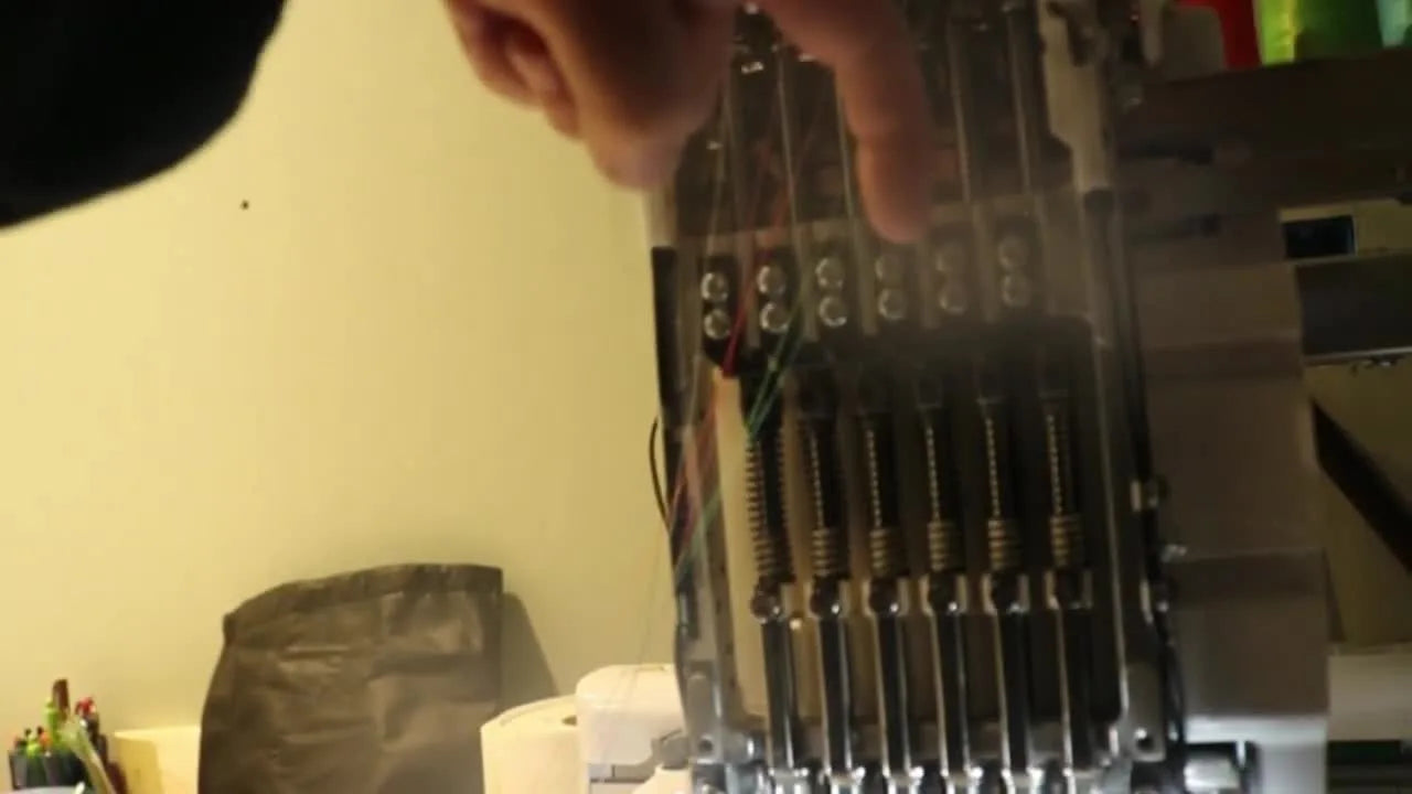 A close-up of the Brother PR655 take-up levers with one lever visibly stuck lower than the others, pinpointing the mechanical jam behind the error.