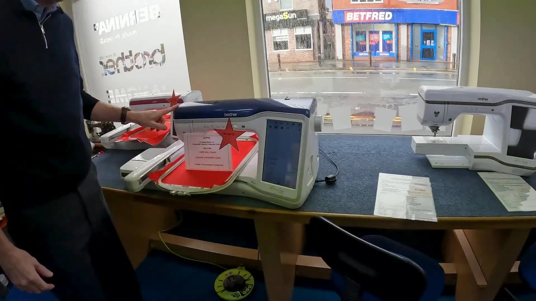 A Brother Stellaire Innov-is XJ1 sits ready with a large hoop holding red fabric, showing the kind of setup you should inspect when evaluating an ex-display machine.