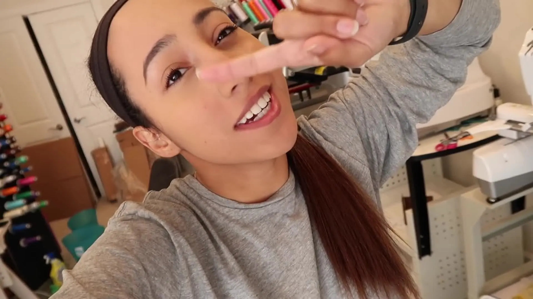 A studio owner slides a magnetic embroidery hoop into a cardboard sleeve and tapes it shut to prevent damage during transport.