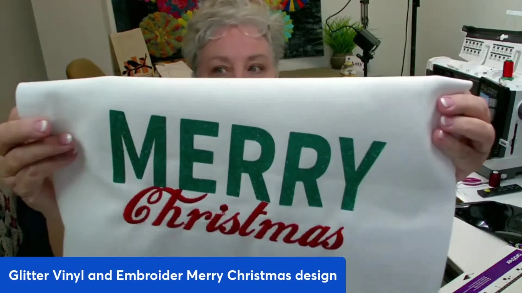 A finished “Merry Christmas” garment showing red embroidered text paired with green glitter vinyl for a crisp mixed-media look.