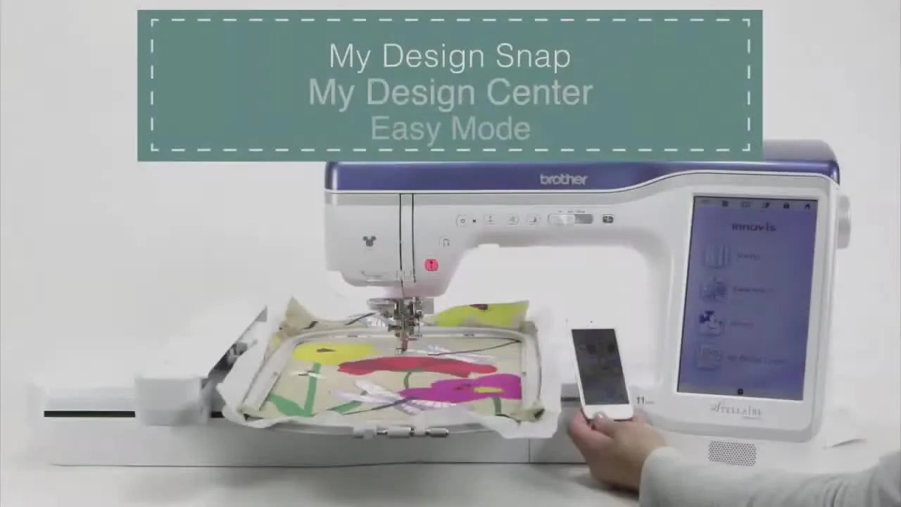 Brother Innov-ís XJ1 embroidery machine with a smartphone displaying the 'My Design Snap' app next to it, showing a hooped fabric with an embroidered floral design.
