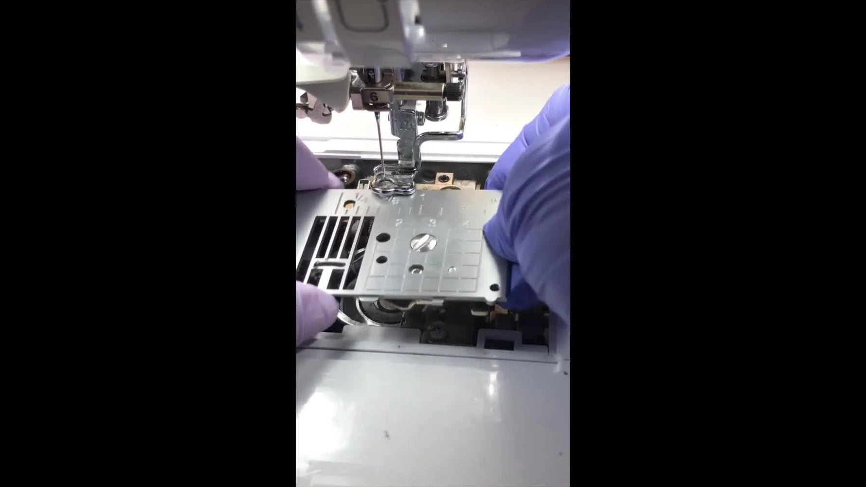 The Brother Dream Machine needle plate is removed, revealing lint buildup around the feed dogs and internal mechanism before deep cleaning.