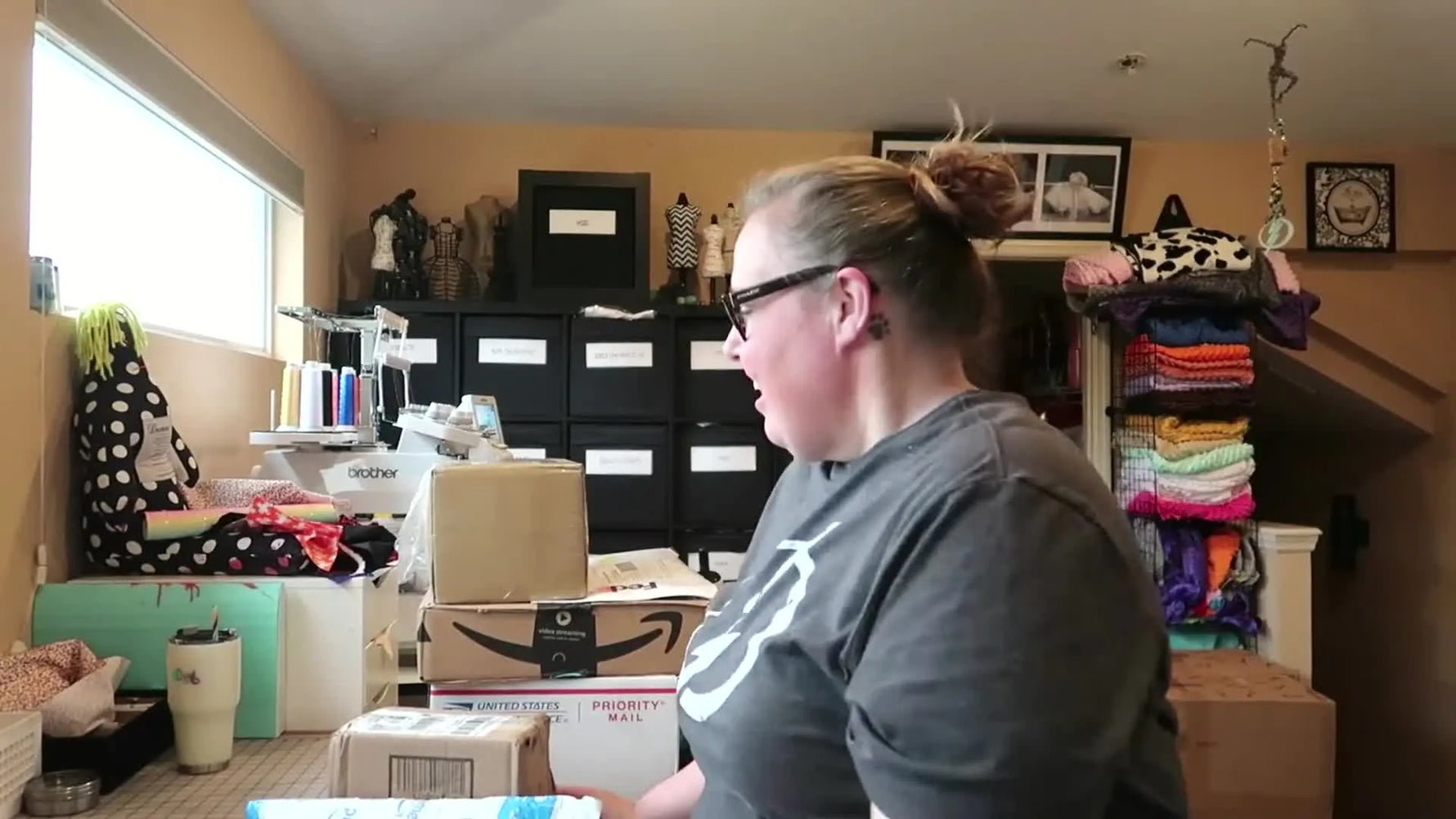 Vlogger smiling at the camera, with her craft room in the background.