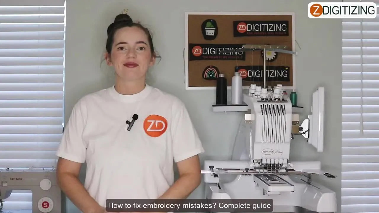 Woman in white ZDigitizing t-shirt standing in front of an embroidery machine, gesturing with open hands.