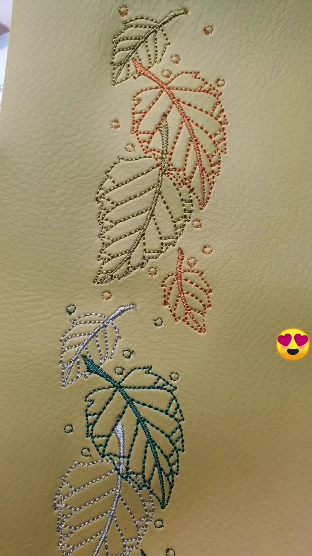 Close-up of embroidered vinyl with multiple leaf designs in various colors.