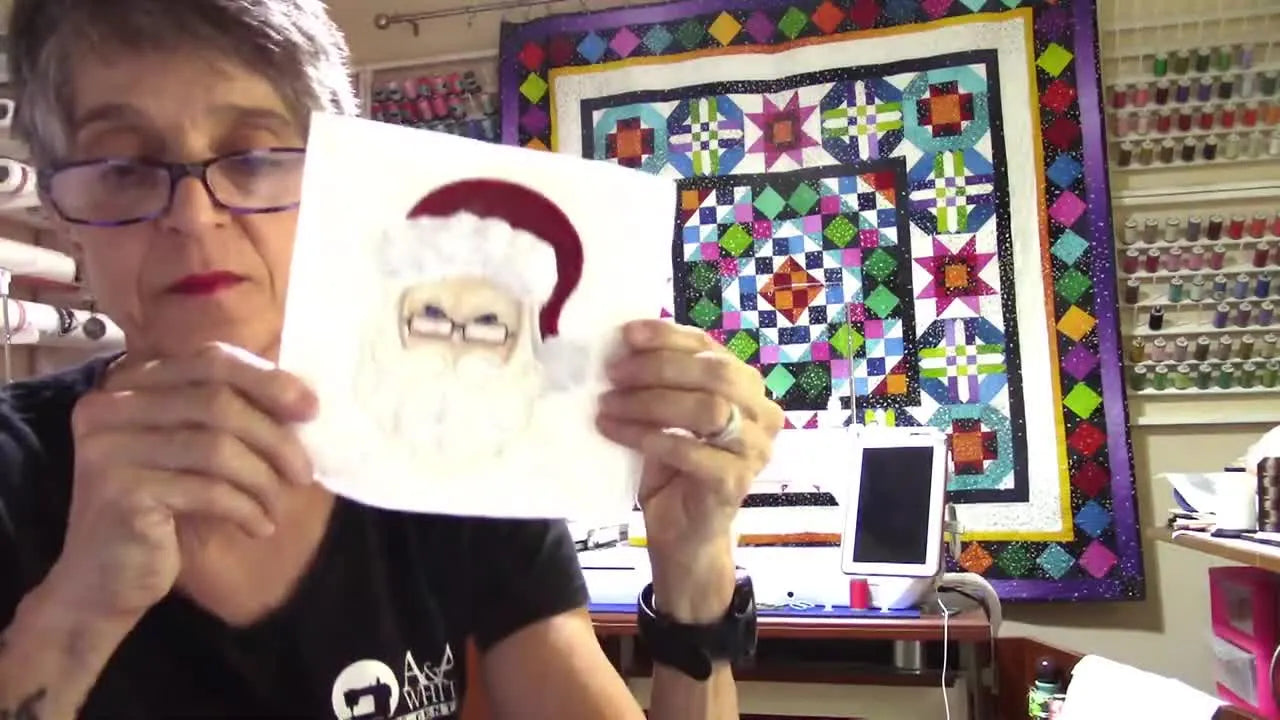 A close-up of the Santa quilt block with a textured Shannon Cuddle beard and shiny vinyl glasses, held up for inspection.