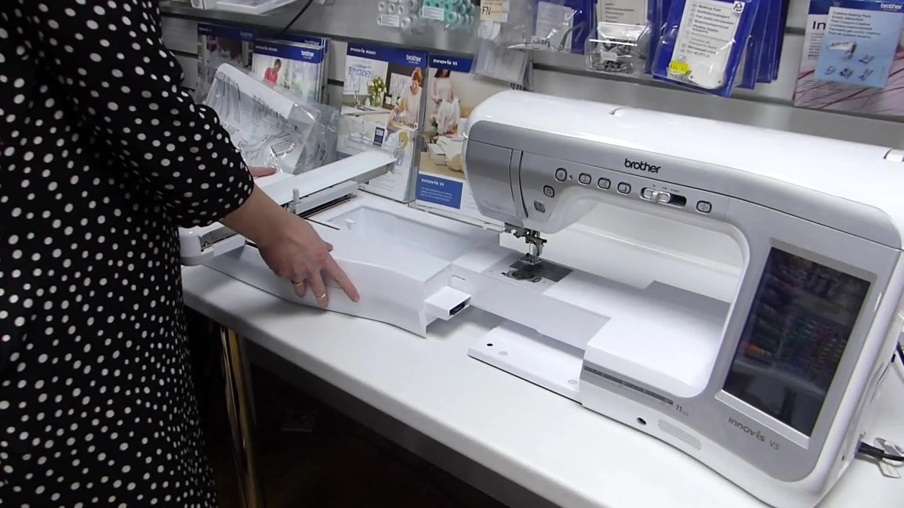 A close-up of the Brother Innov-is V5 embroidery unit being slid onto the machine’s free arm until it seats flush.