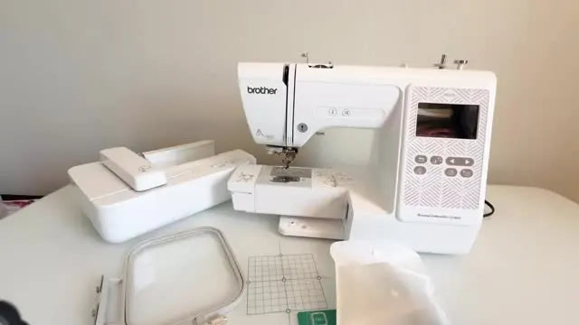 A Brother PE570 embroidery machine and its key accessories laid out on a table, ready for first-time setup.