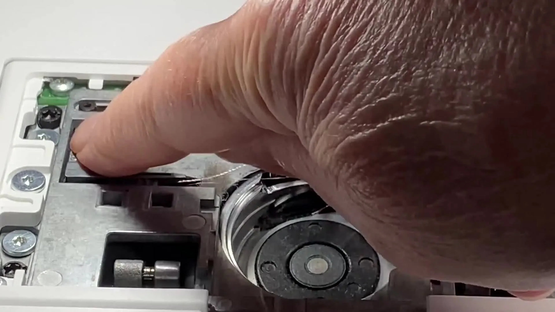 An extreme close-up shows the hidden sliding bar moved left to expose the EPIC 2 thread cutter area for deep cleaning.