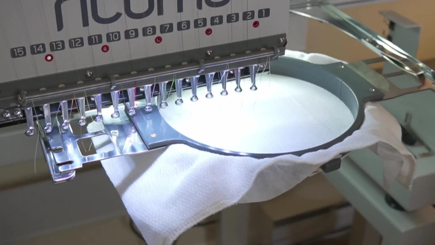 A close-up of the Ricoma MT-1501 stitching an elephant design mid-run, showing texture and stitch formation on terry cloth.