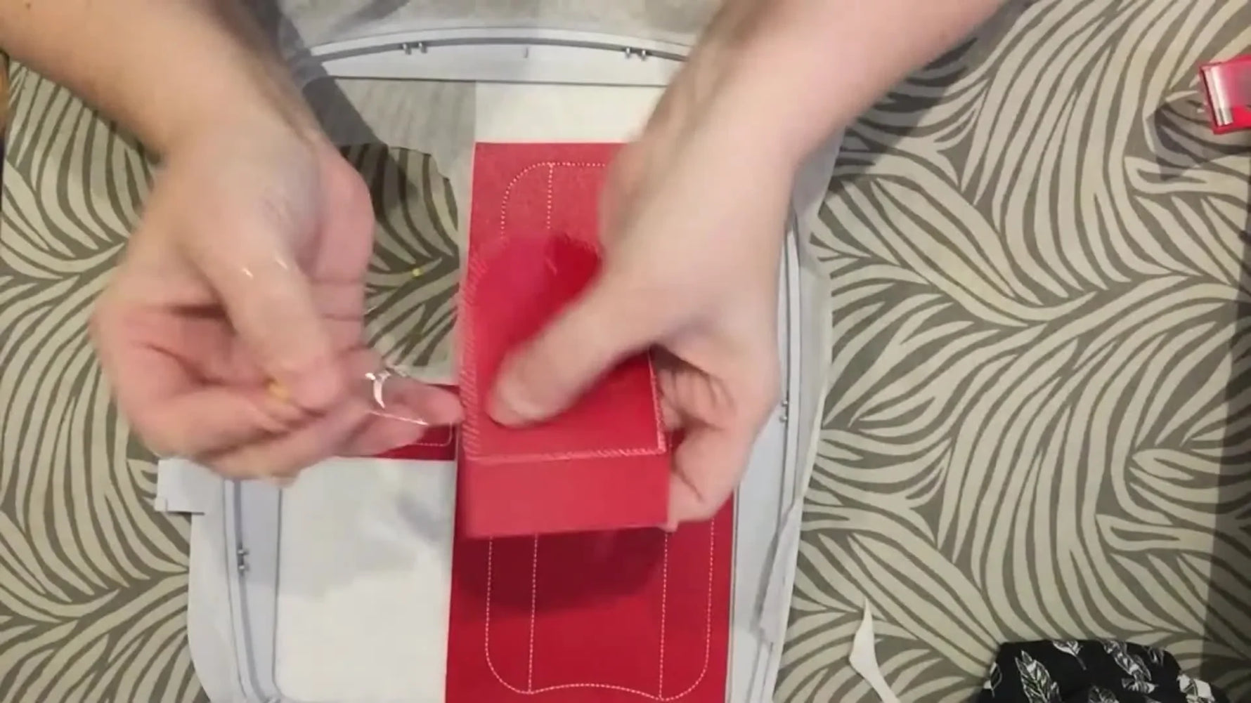 Pins are used inside the hoop to align the pre-stitched vinyl flap perfectly to the main body before the final attachment stitch runs.