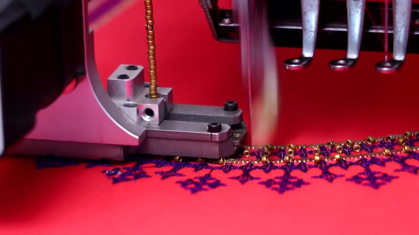 A macro close-up shows an automated beading device stitching a gold bead chain onto red saree fabric beside purple embroidery.