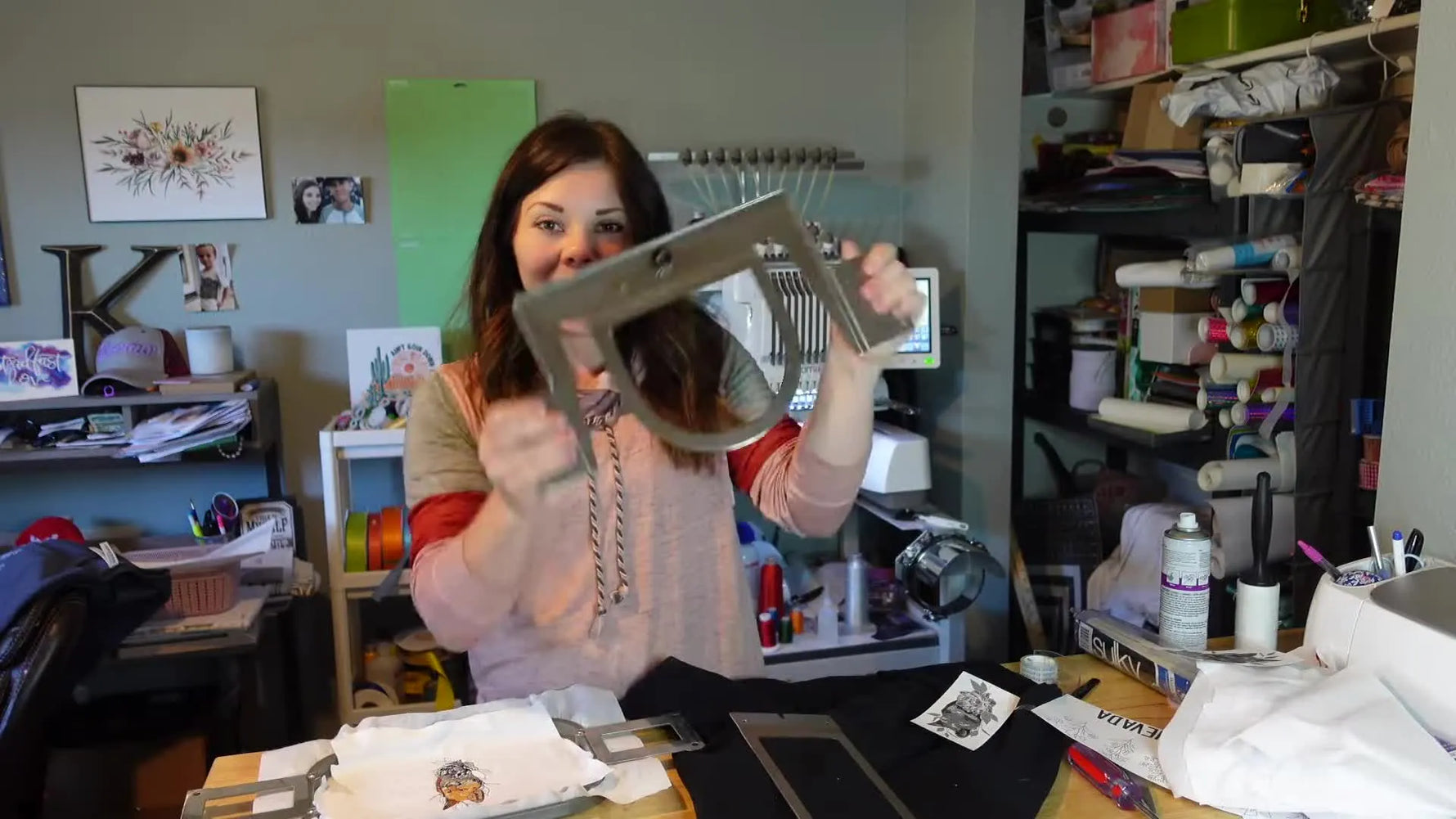 Woman holding up an assembled Fast Frame bracket with a U-shaped sleeve frame attached.