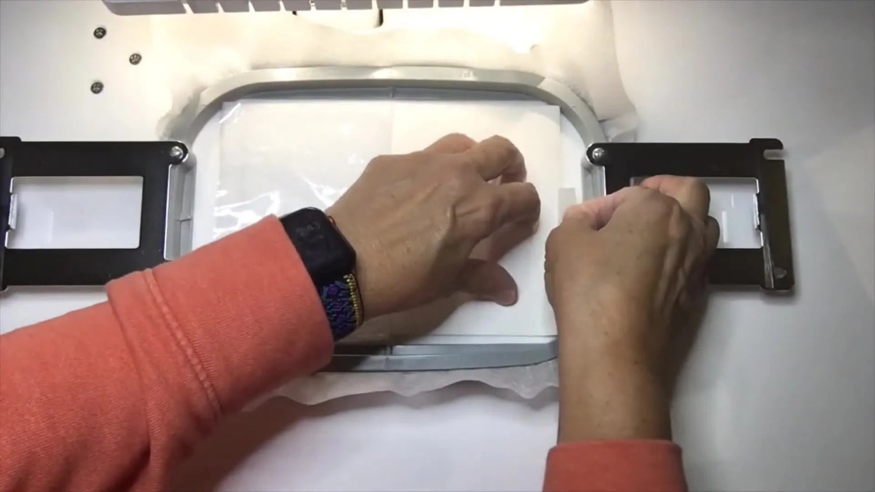 Overhead view of taping the top edge of marine vinyl inside a magnetic hoop to prevent shifting during an ITH stitch-out.