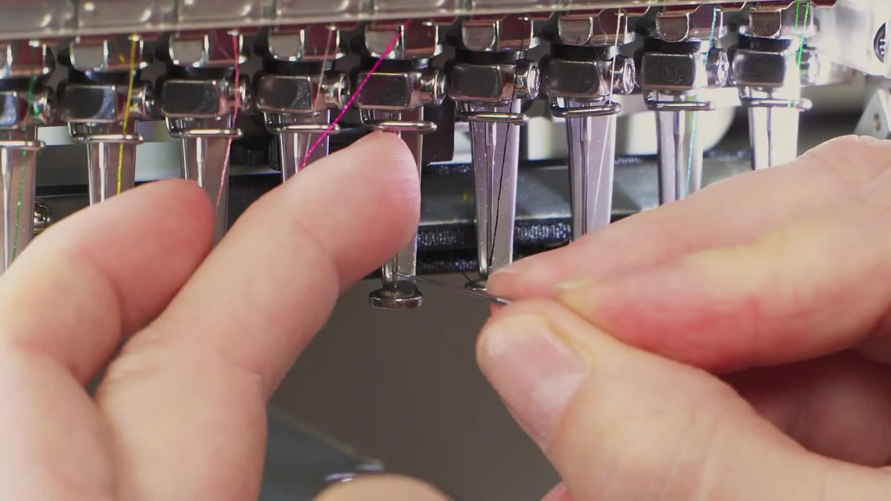 A close-up shows an old needle inserted into the eye of a new needle to hold it steady while aligning the round shank needle to the 11 o’clock position.