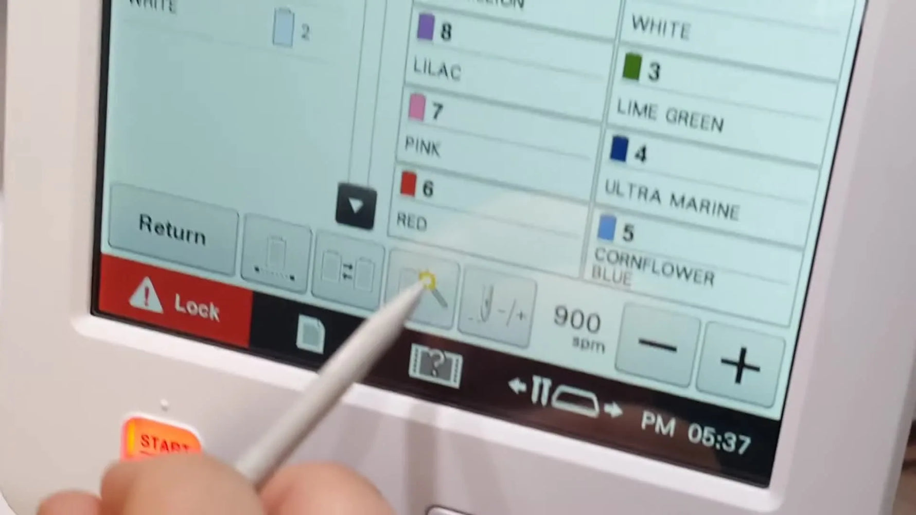 A close-up of the Baby Lock Valiant touchscreen as a stylus points to the Magic Wand icon used for temporary needle assignment.
