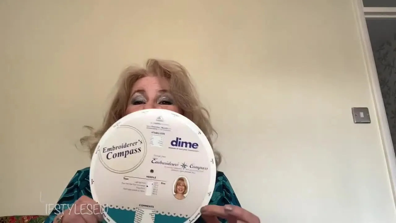A close-up of the Dime Embroiderer’s Compass being held up as a quick reference tool for choosing stabilizer and needle combinations.