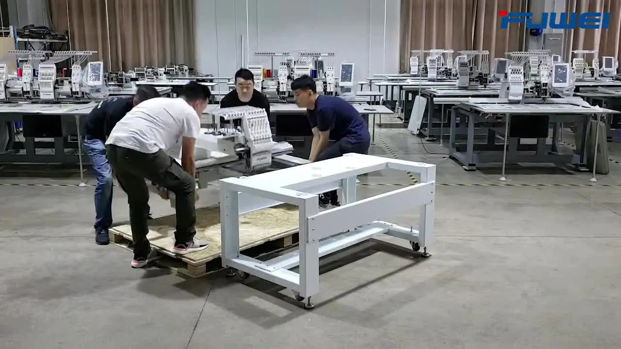 Four technicians team-lift the FUWEI FWP-1201 embroidery head from the pallet and lower it onto the wheeled stand for final bolting.