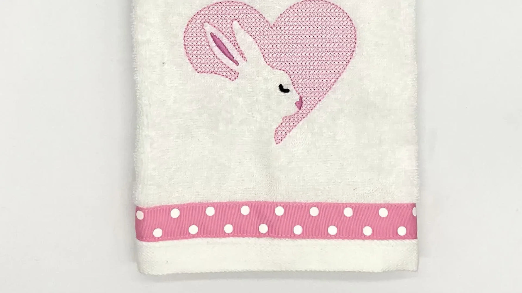 Close-up of the finished embossed bunny heart stitched on a terry towel, showing the raised nap contrast around the motif fill.