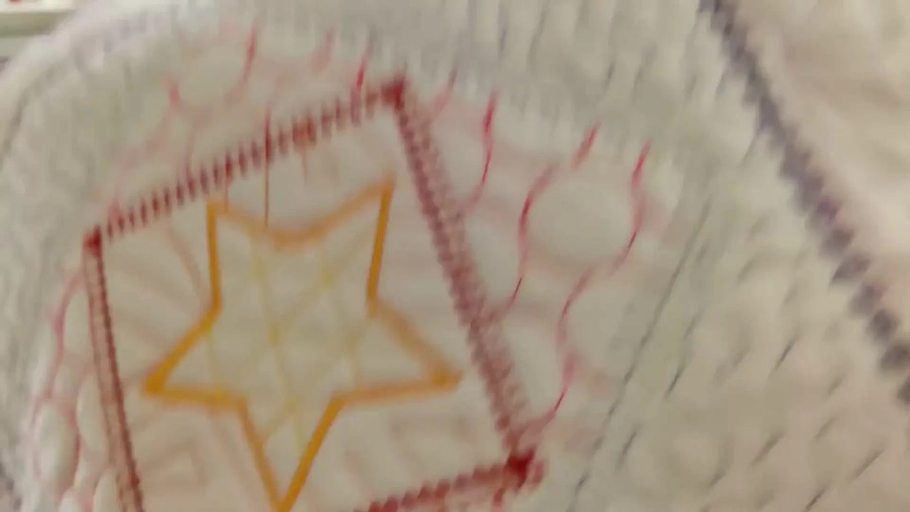 A close-up of the finished quilted cushion block with crisp geometric embroidery in multiple colors.