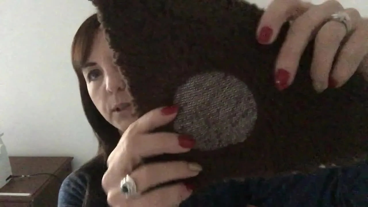 A close-up of a finished knockdown (nap/loft down) circle stitched on brown Sherpa, creating a flattened base that keeps monogram letters visible.