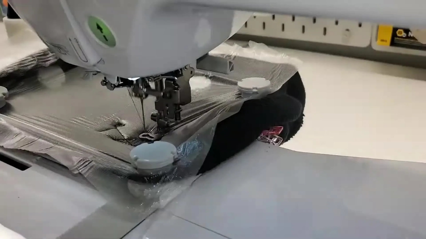 Hooped beanie being placed onto a Brother PE800 single-needle embroidery machine.