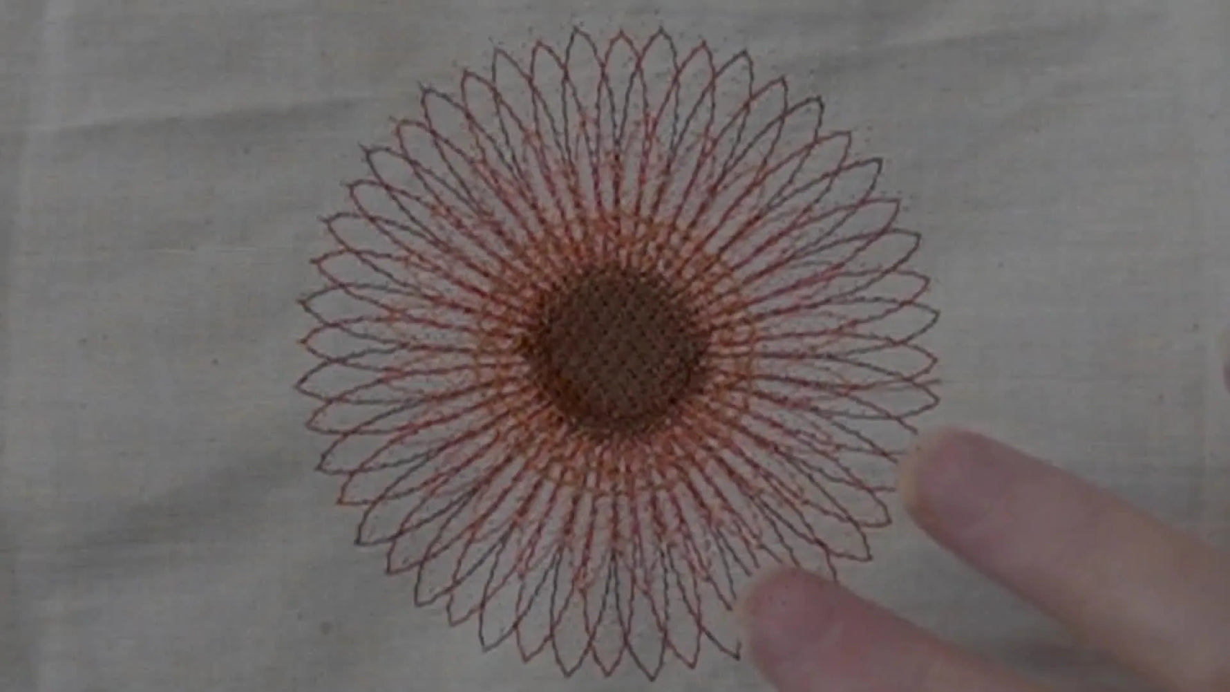 A finished multi-colored flower mandala stitched on calico, shown flat and centered for a clean, confidence-building first embroidery result.