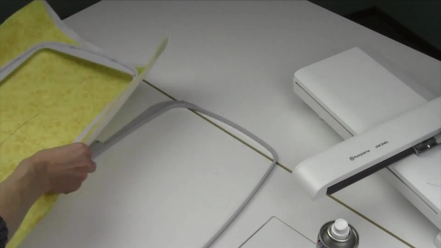 An overhead view shows the inner hoop being positioned into the outer hoop with the fabric-and-stabilizer sandwich aligned and ready to lock in.