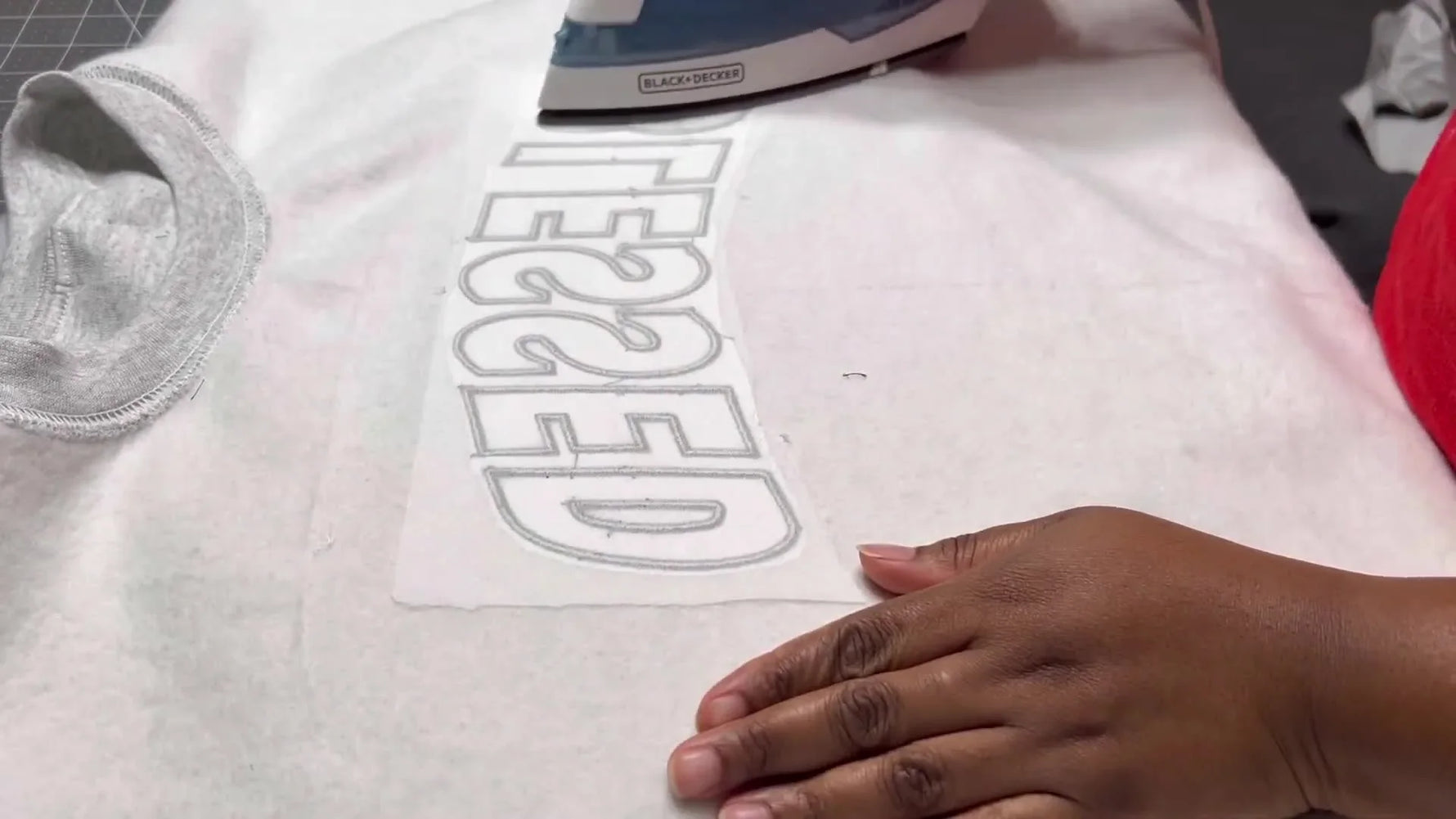 A finished “BLESSED” plaid appliqué sweatshirt is styled in a flat lay, showing crisp edges and a clean, sell-ready look.