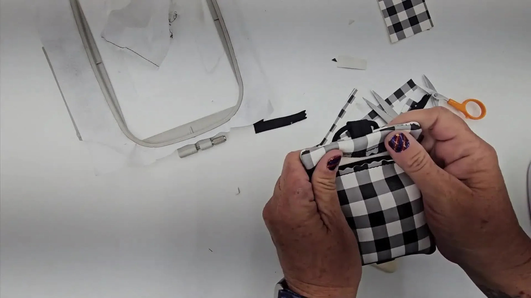 A finished plaid ITH tumbler bag with elastic loops, shown flat so you can clearly see the zipper, tab placement, and final shape.