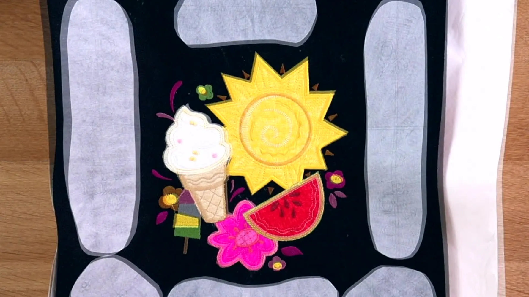 The completed PK10019 Summer Garden Flag design—sun, ice cream, watermelon, and lettering—stitched cleanly while still in the hoop.