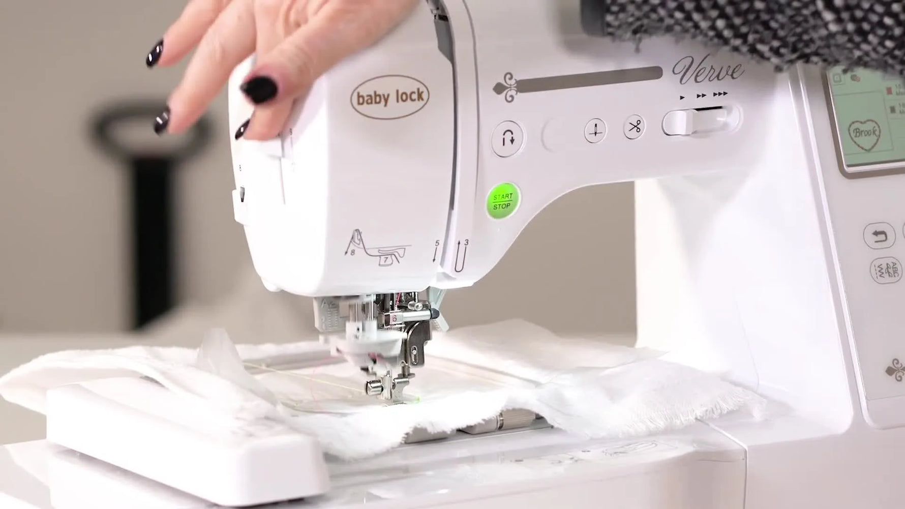 Close-up of engaging the Baby Lock Verve automatic needle threader lever with pink thread at the needle.