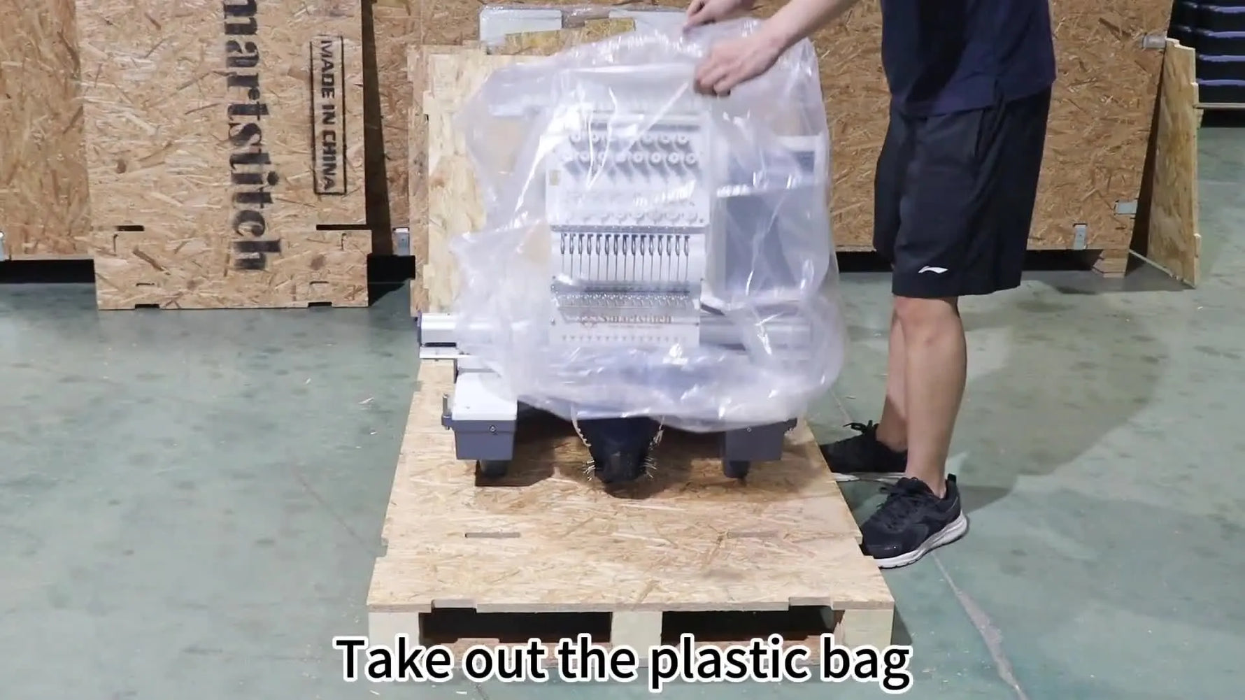 Technicians lift the plastic dust cover to reveal the Smartstitch multi-needle embroidery head for the first time.