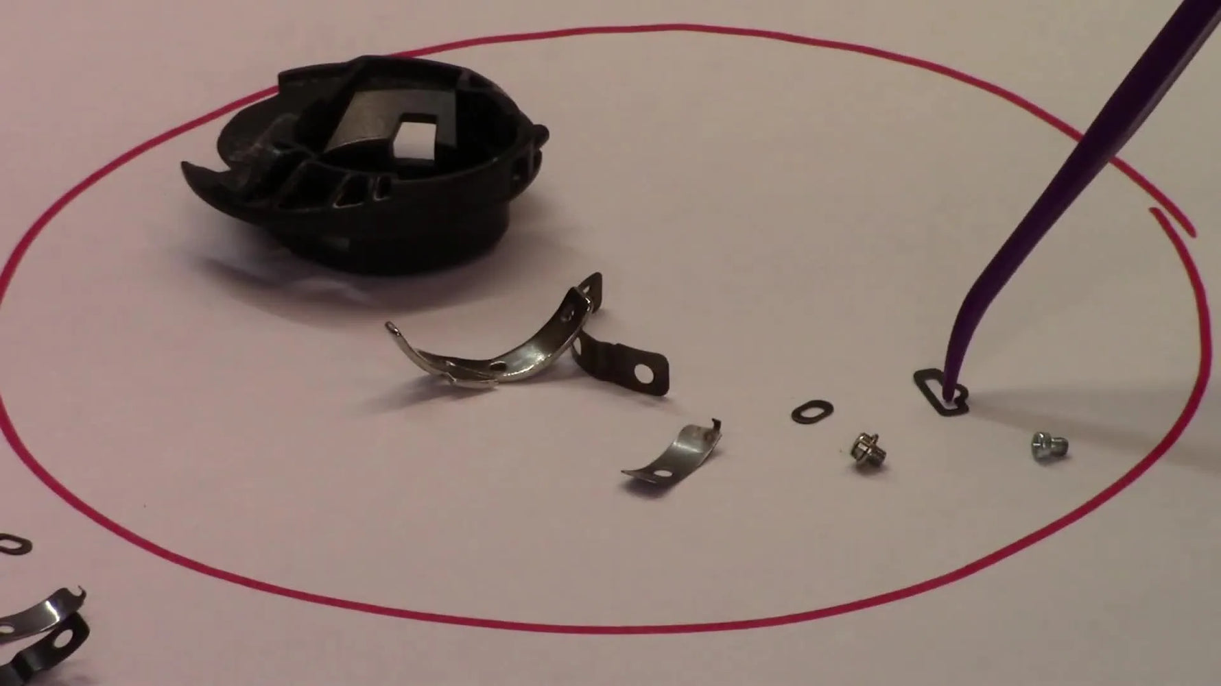 A close-up view shows a pointer isolating the tiny tension spring that makes the Purple Dot bobbin case adjustable.