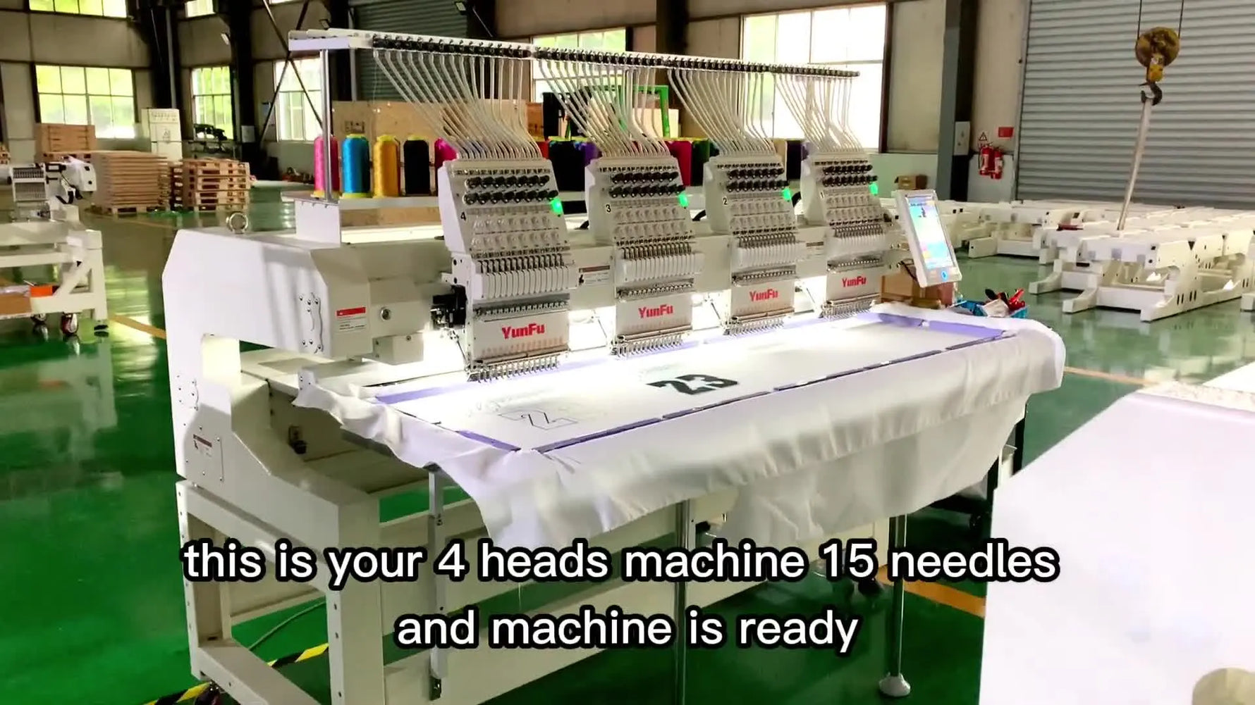 A wide factory-floor view of a 4-head YunFu embroidery machine fully threaded and ready for final testing.