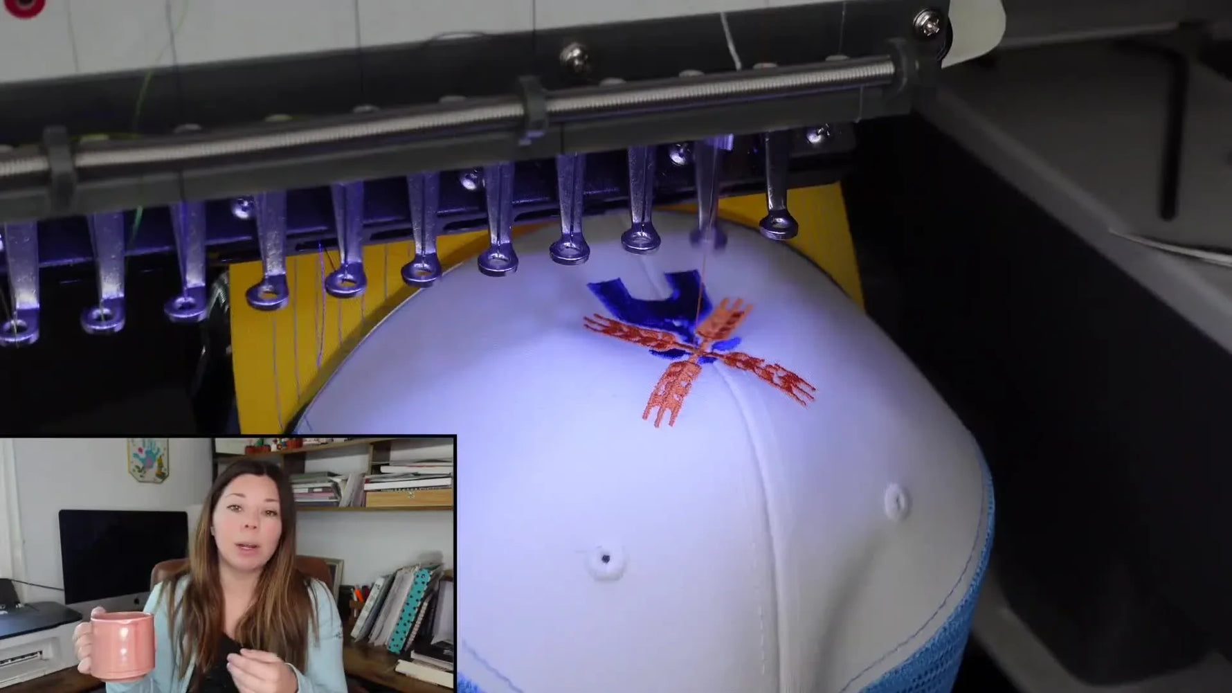 A Ricoma multi-needle embroidery machine stitches a bright design onto a cap on the driver, capturing the pace of real production work.