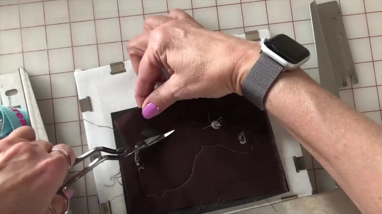 Close-up of precision trimming craft foam with tweezers and curved scissors right next to the stitch line for a crisp satin edge.