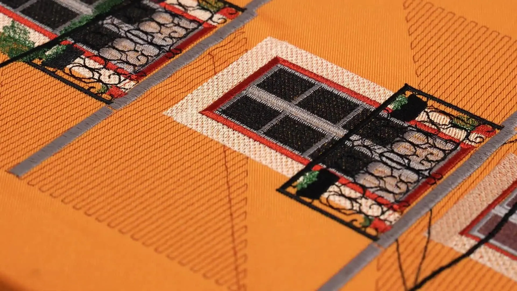 A finished embroidery painting of a yellow Portuguese building facade is neatly mounted on a canvas frame, ready to hang as textured wall art.