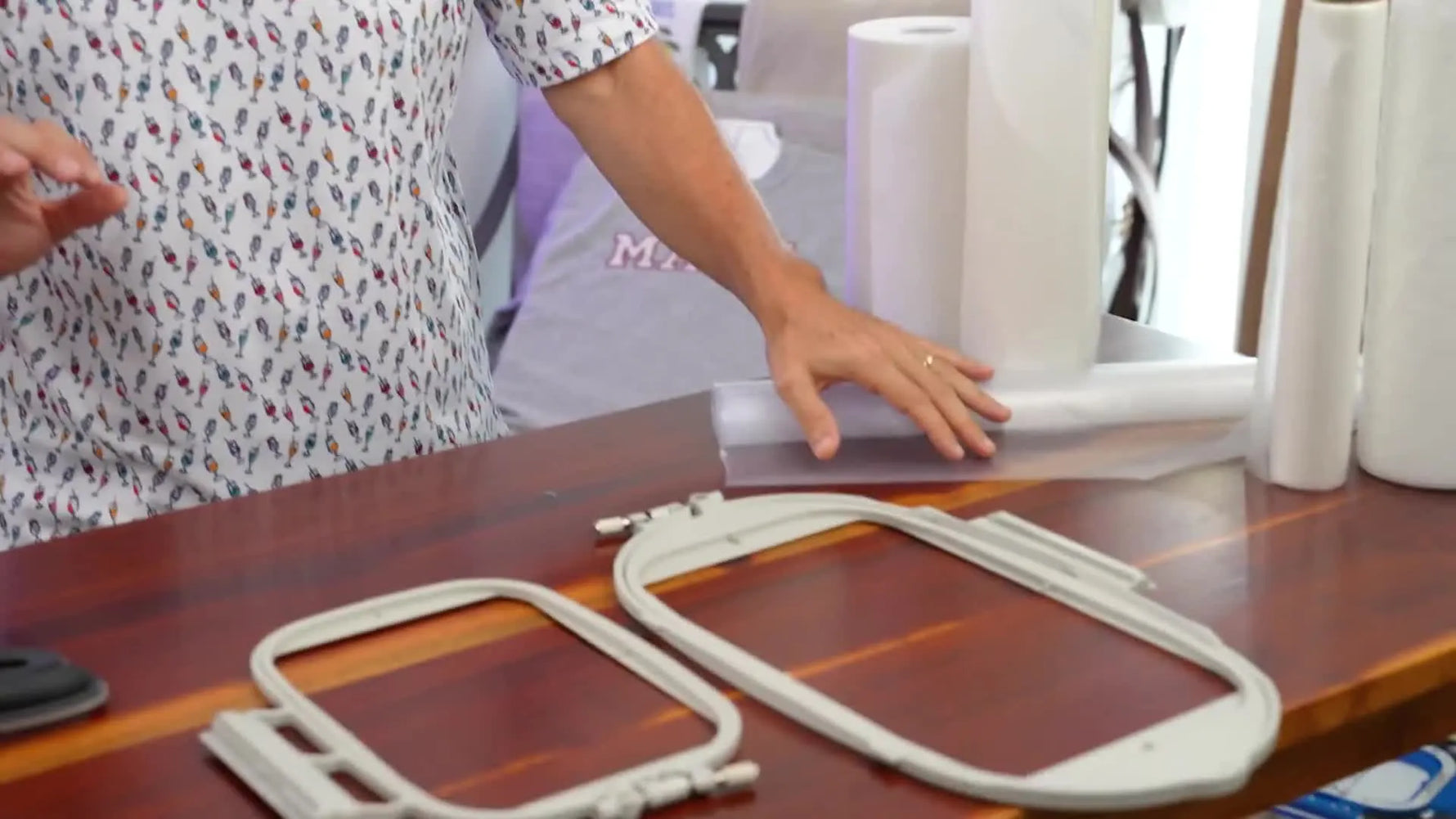 A close-up of magnetic embroidery hoops beside multiple stabilizer rolls, setting up a clear “choose the right stabilizer” workflow.
