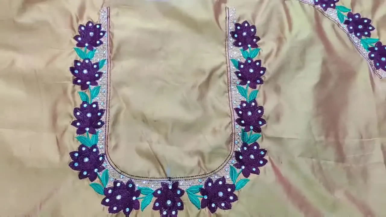 A finished floral blouse neckline embroidery with added mirror/stone embellishments laid flat for a final reveal.