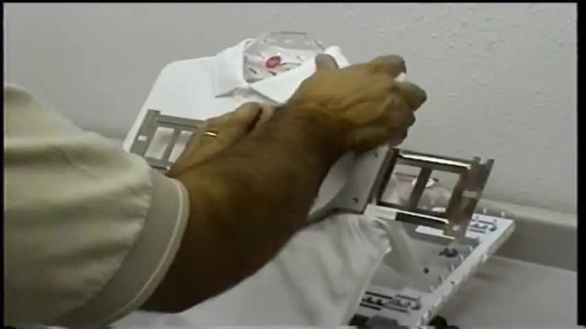 Top hoop being pressed firmly onto a white polo shirt on the hooping device.