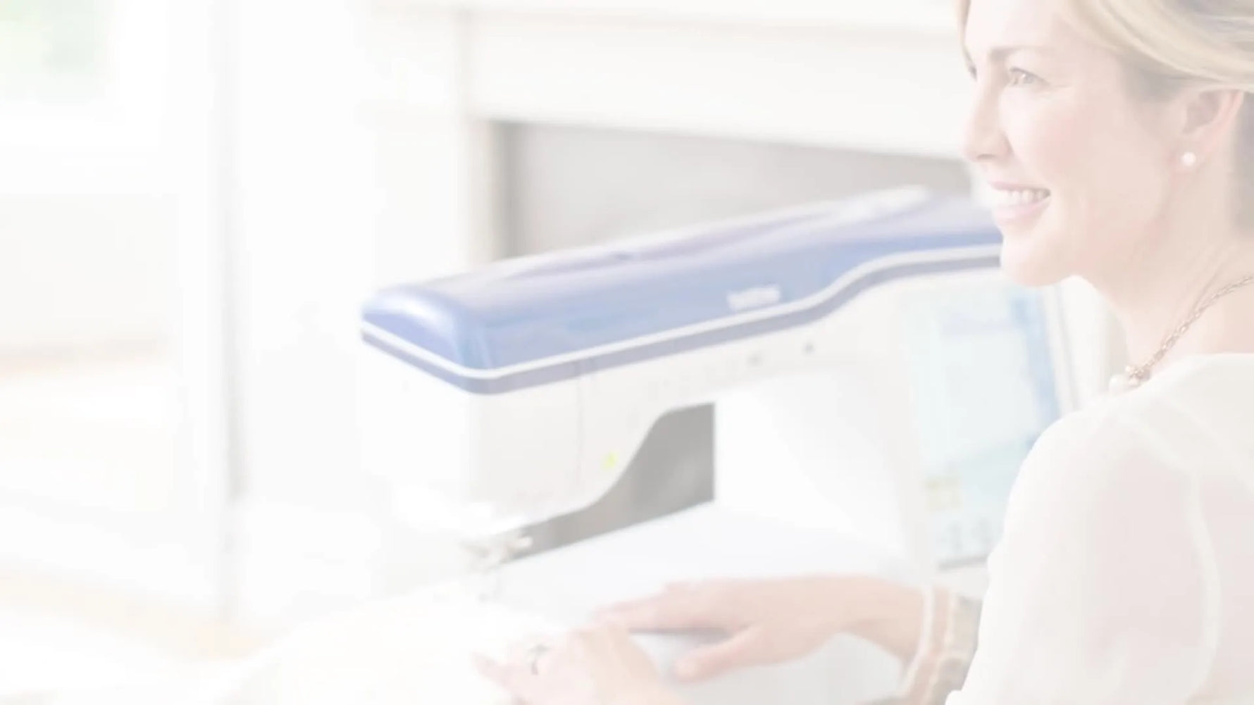 Woman smiling while operating a Brother Innov-is XV sewing machine.