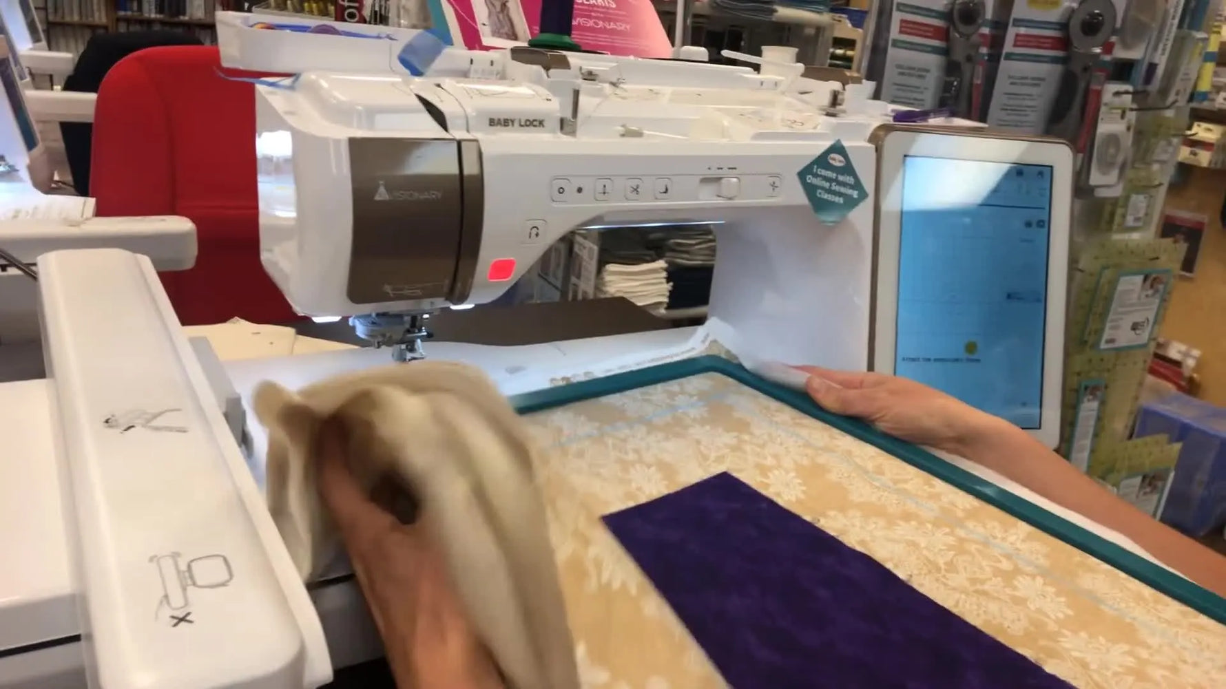 A magnetic snap hoop is pressed into place over a quilt sandwich on the Baby Lock Solaris, ready for border quilting.