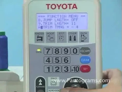 A close-up of the Toyota 9100 control panel as the operator adjusts Trim Timing to a negative value for cleaner metallic-thread cuts.