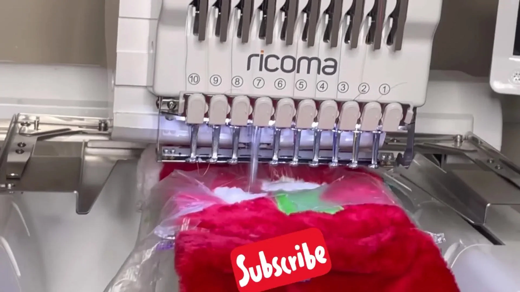 Close-up of the Ricoma EM-1010 stitching the final satin border over water-soluble topping on a plush Christmas stocking appliqué.