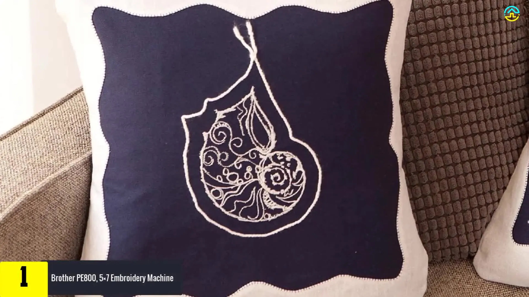 A decorative pillow with a large floral embroidery sits beside a Brother PE800, highlighting what a 5x7 field enables on home machines.
