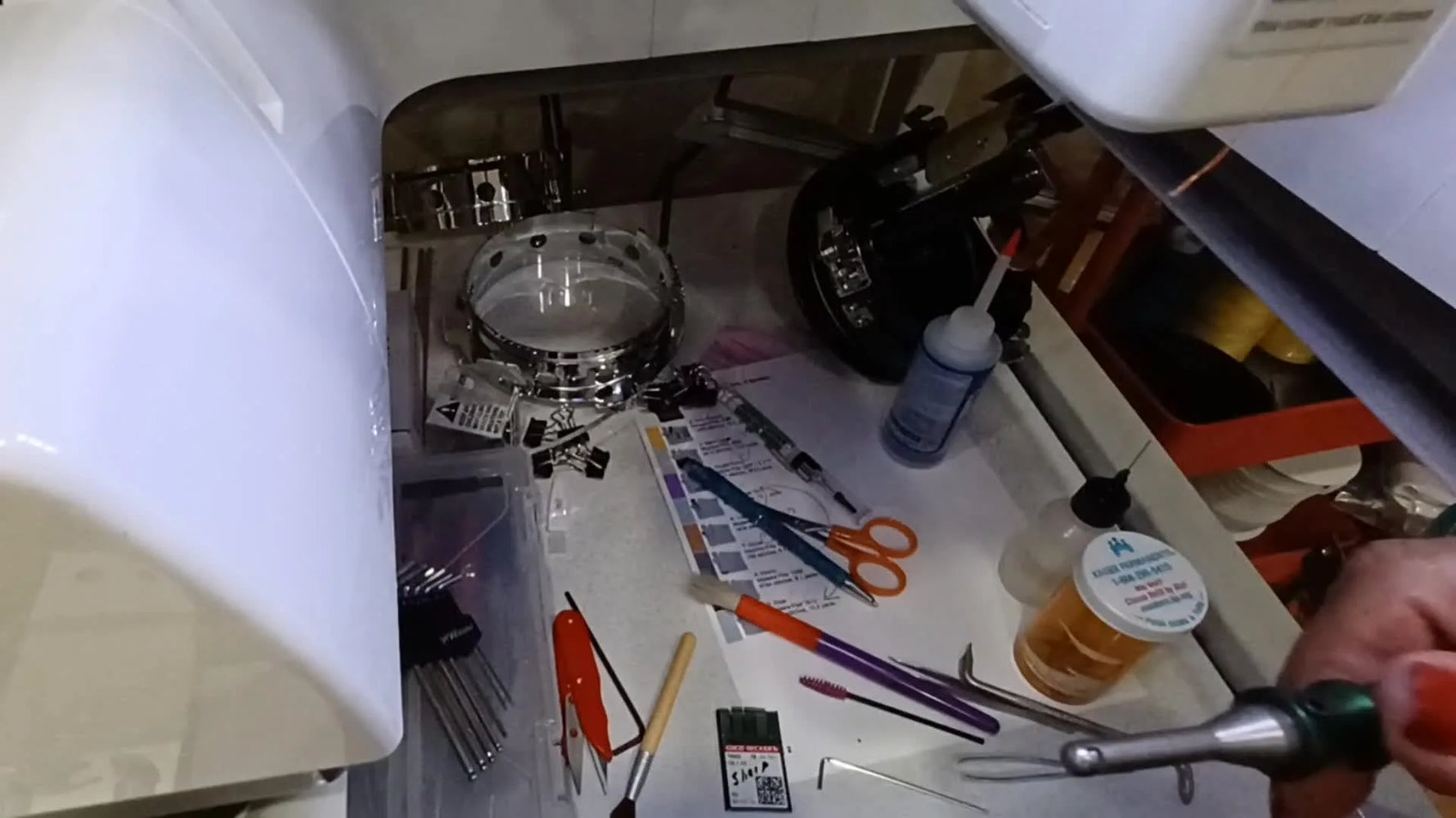 Close-up of the Needle Ease tool’s collet mechanism used to align and insert an embroidery needle correctly.