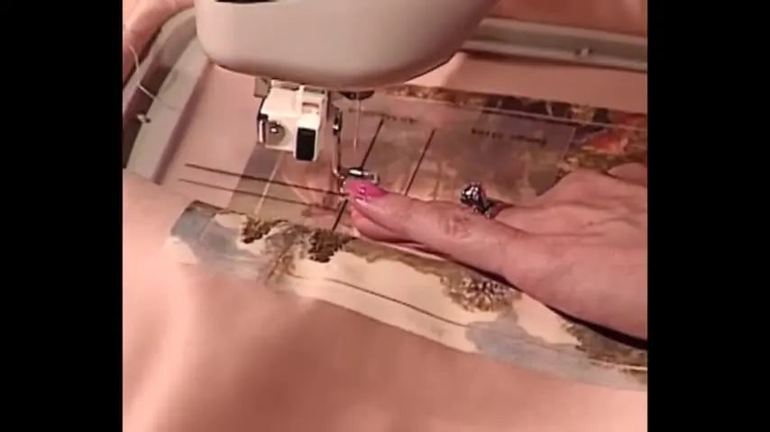 An extreme close-up shows the needle lowered to touch a crosshair on a paper template for precise embroidery placement in a 5x7 hoop.