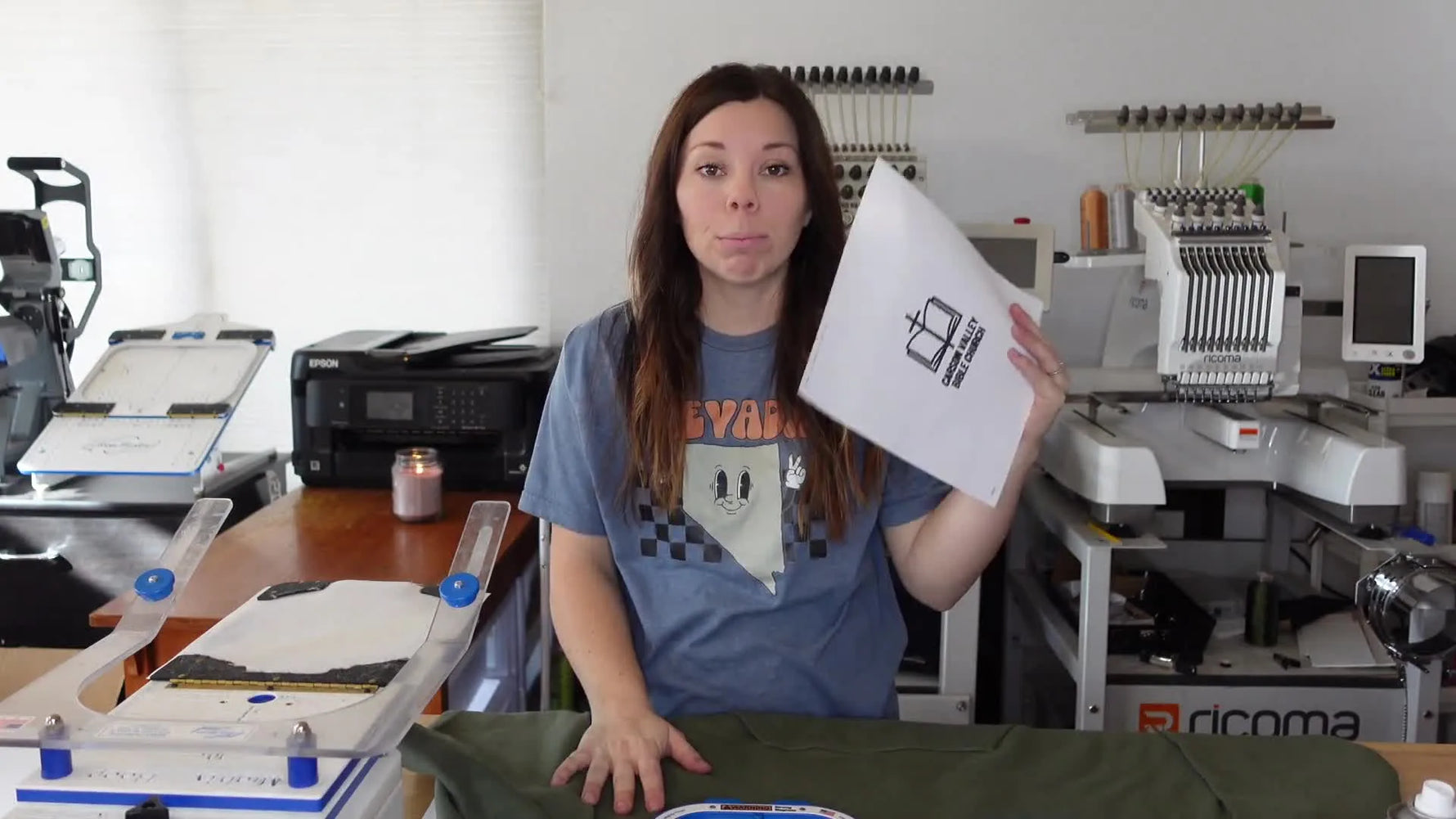 Woman holding up a printed paper design template with crosshairs.